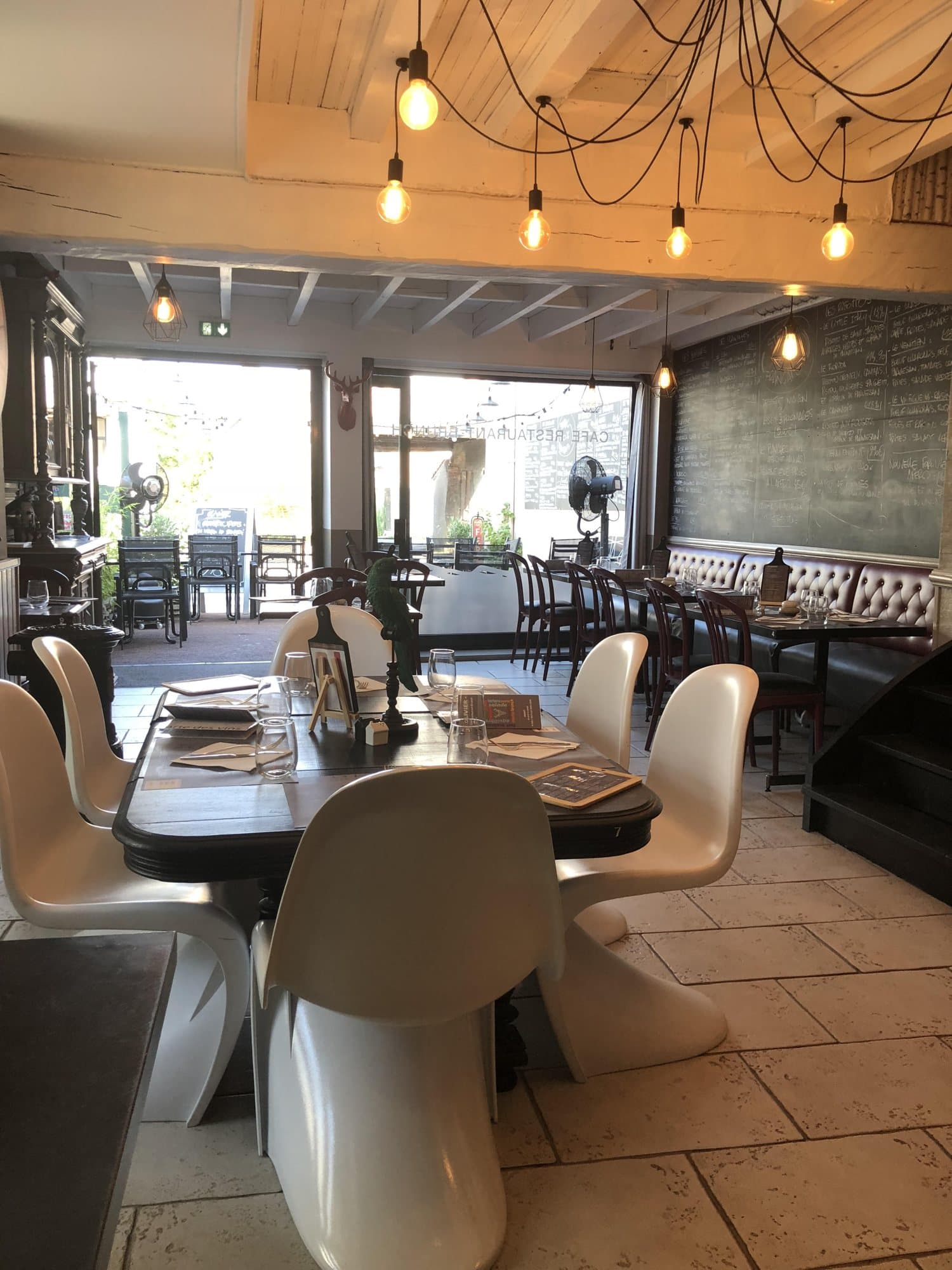 Chaises design et tables dressées sous les ampoules